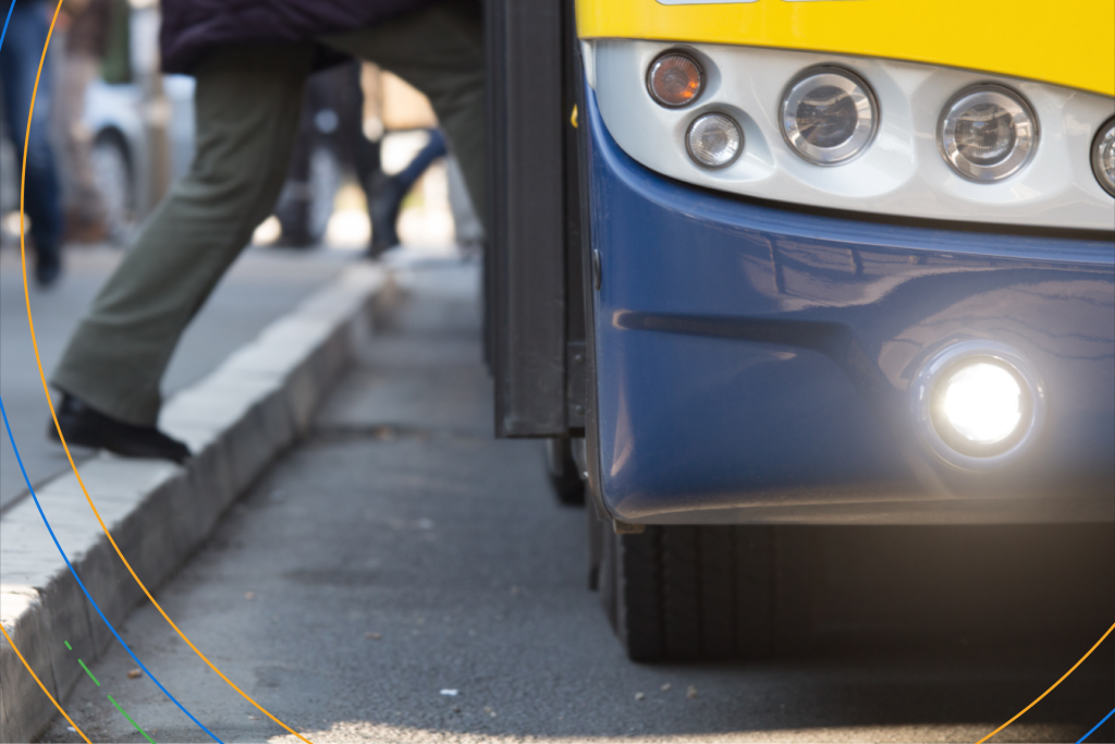 the feet of someone stepping onto a public bus