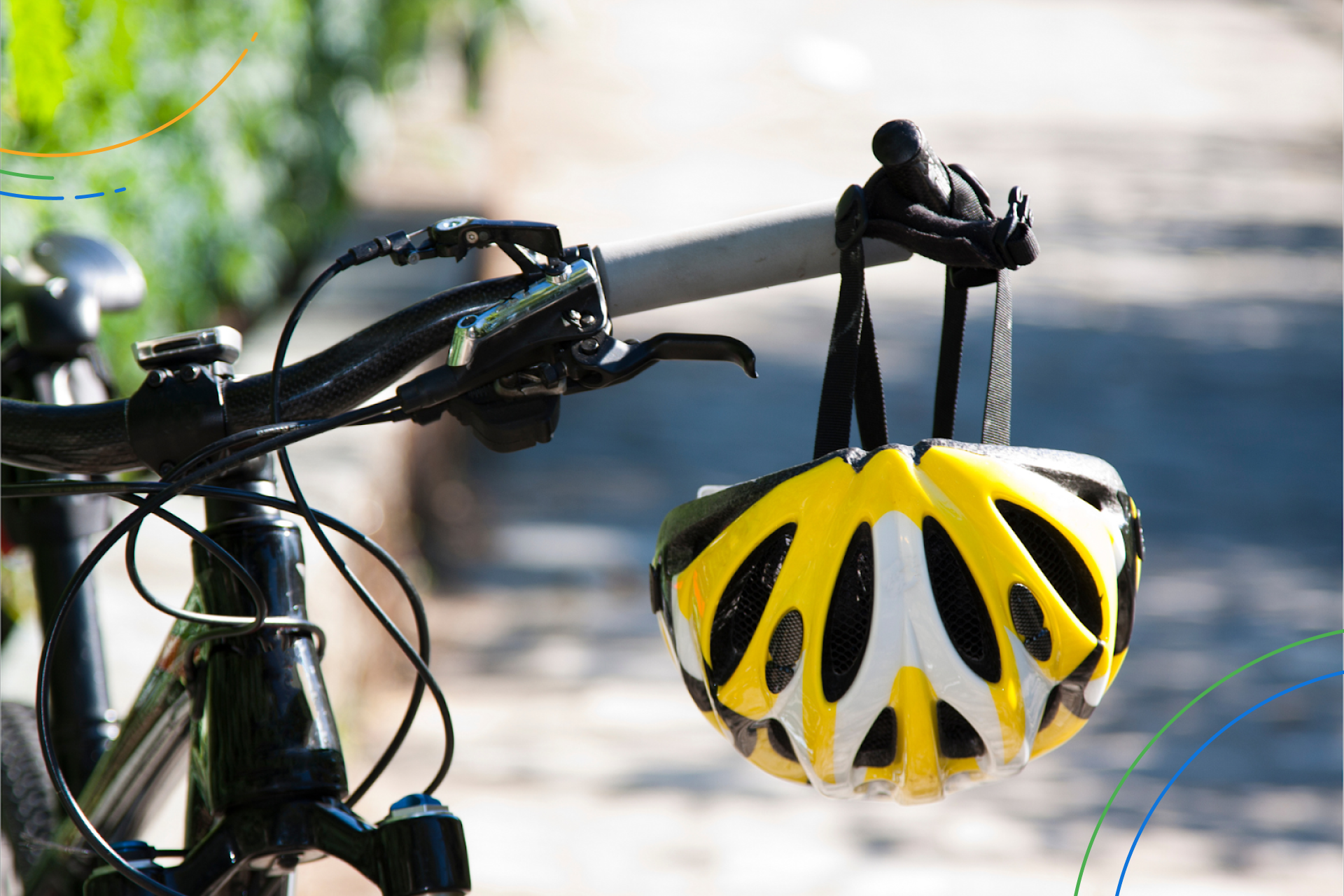 a yellow bike helmet hanging from a bike’s handlebars