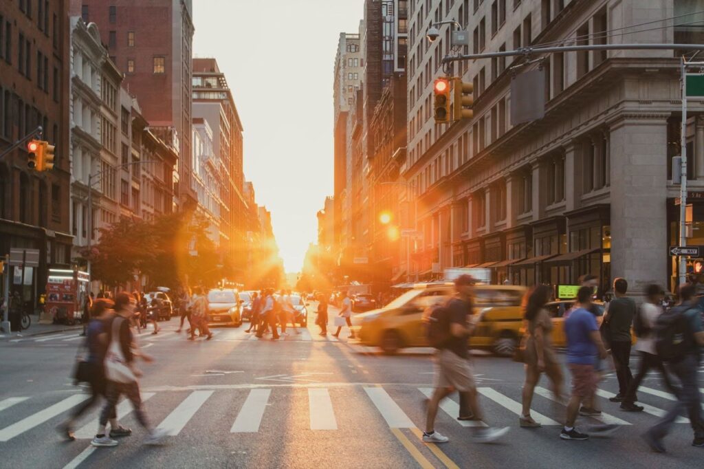 Busy intersection with people crossing at a crosswalk amidst city traffic