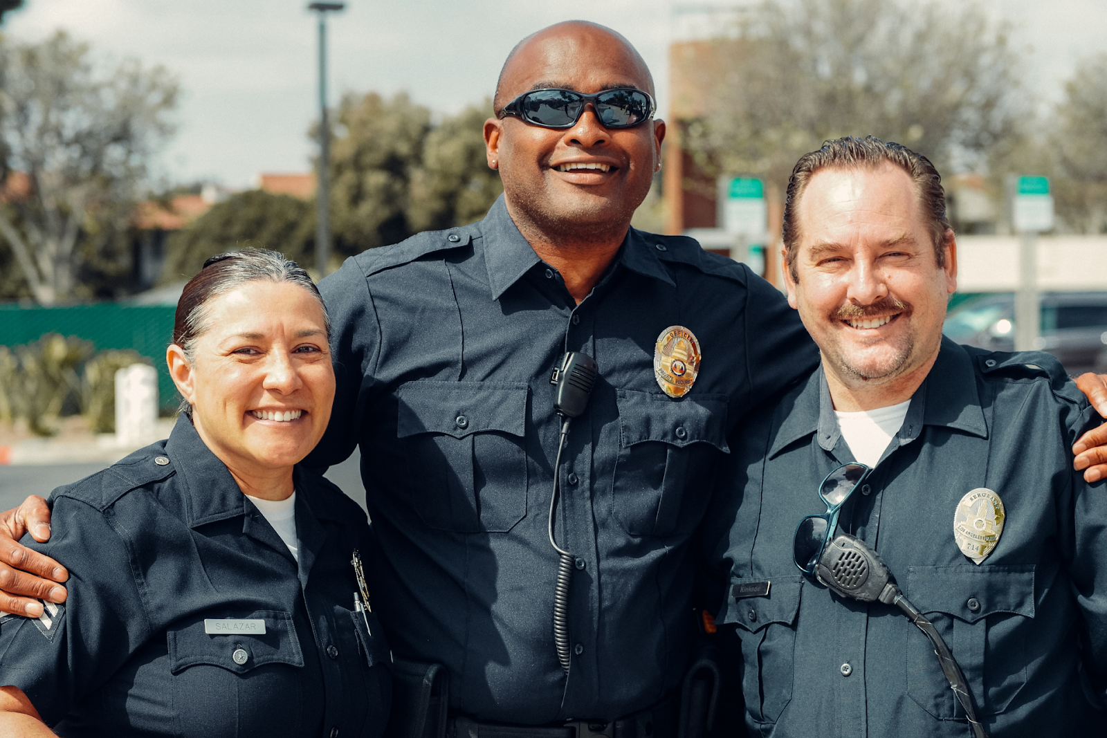 Three uniformed, smiling police officers.