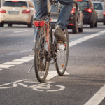 A cyclist on the road emphasizes pedestrian and cyclist safety.