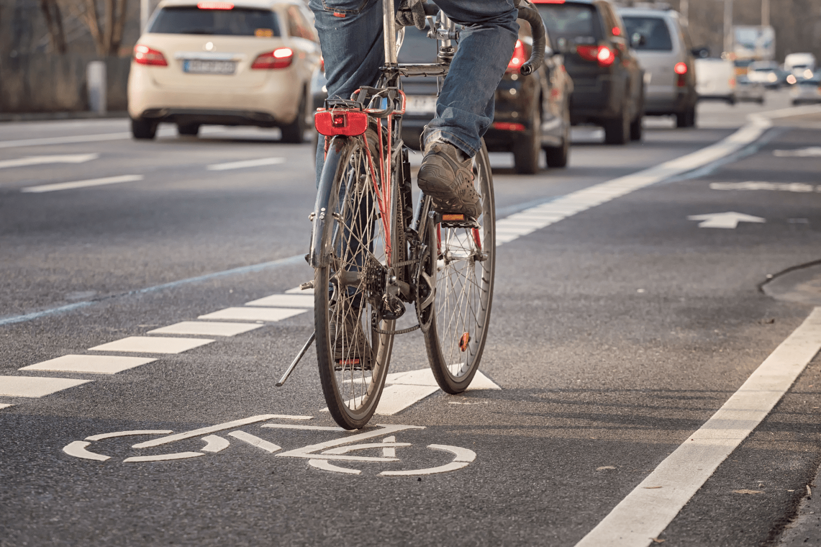 A cyclist on the road emphasizes pedestrian and cyclist safety.