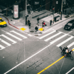 The corner of an intersection with cyclists, pedestrians, and cars