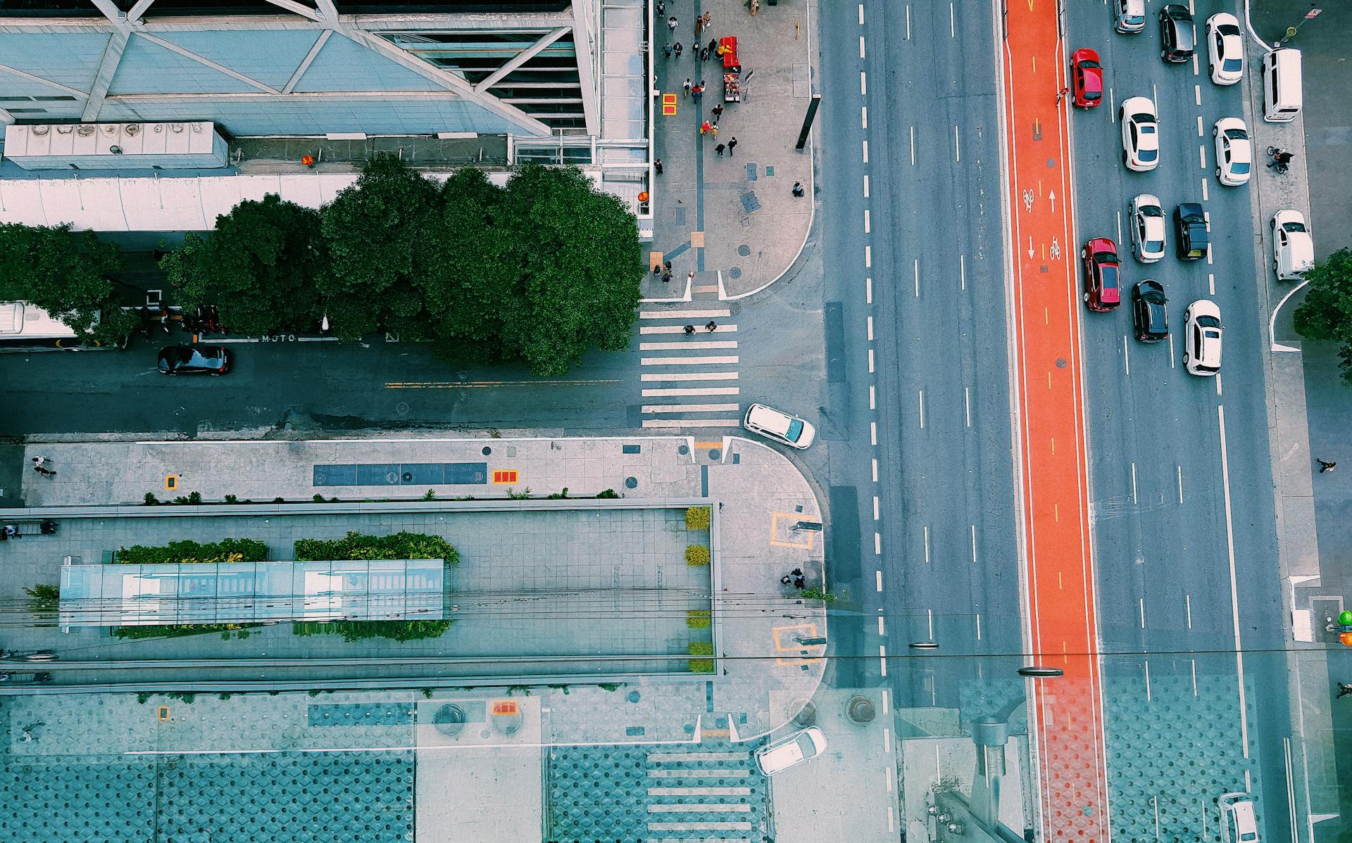 Aerial top-down view of a city street intersection with crosswalks, sidewalks, and a multi-lane road